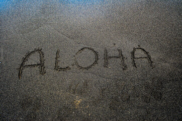 Fototapeta premium The word Aloha, written into the black sandy beach on the Big Island of Hawaii