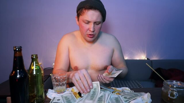 Redneck counts money and drinks alcohol