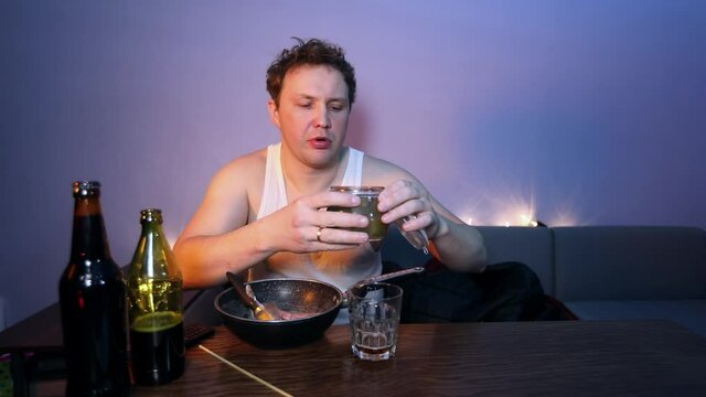Chuff men eats a pickles, drinks beer and scratches his chest