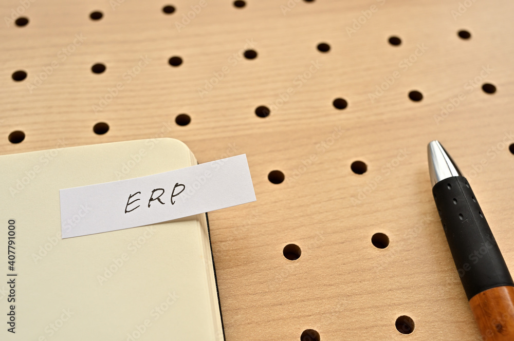Poster a sticky note with erp written on the edge of an open notebook on the punching board. that's an acro