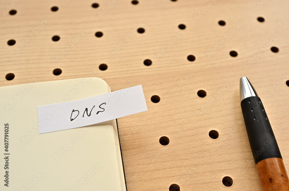 Poster a sticky note with dns written on the edge of an open notebook on the punching board. that's an acro