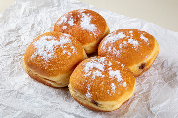 Fresh baked and garnished with powdered sugar german doughnuts - Berliner or Krapfen - on white...