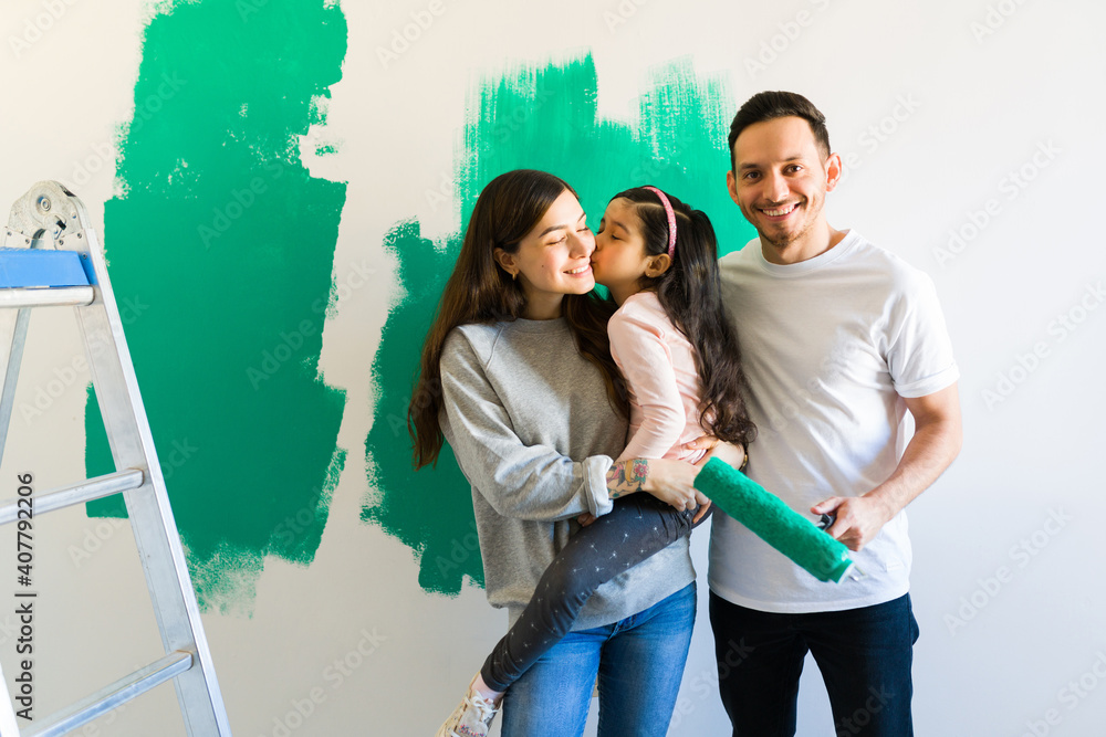 Wall mural Loving family doing a painting project in their home