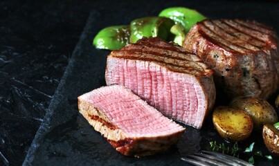 grill filet mignon and vegetables, grilled - young potatoes and peppers. steak mignon from the meat of young beef is shown in section, the degree of preparation is 