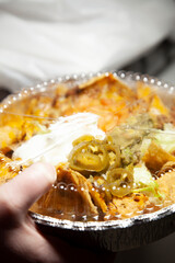 Woman Grabbing Takeout Tin of Nachos
