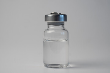 Small bottle with transparent medicine close-up on white background