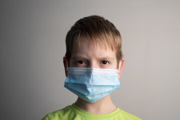 Little boy in a medical mask protection from coronavirus close-up on a white background