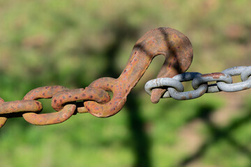 Rusty hook on a heavy chain outdoors
