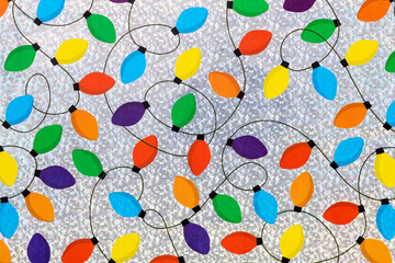 Colorful Christmas lights chain on a silver background.