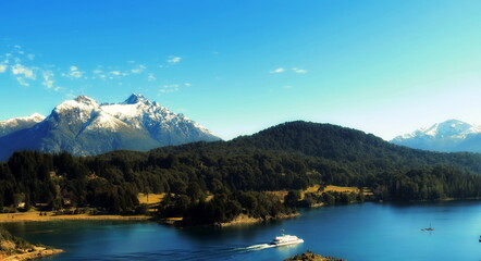 Fototapeta na wymiar Wonderful view of the snowy mountains, lake, forest and blue sky.