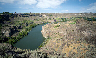 Winding Snake River flowing thru the pacific northwest in the summertime on a partly cloudy day