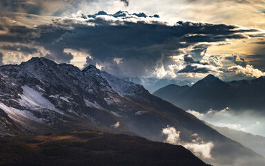 Landscape of rocky mountains under the sunlight and a stormy sky in Sondrio, Italy