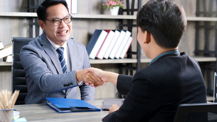 Asian men handshake successfully in job interview at office background, job search, business concept