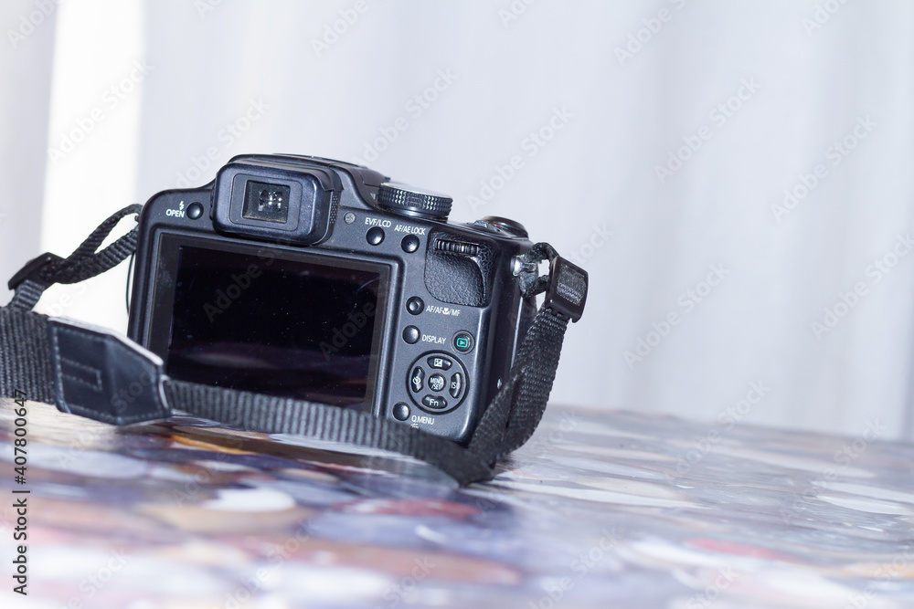 Wall mural front view of a digital camera on a table