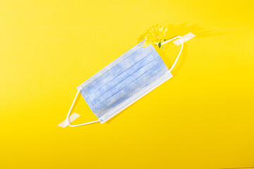 Medical or surgical face mask isolated on yellow background, coronavirus and infection protection. Copy space
