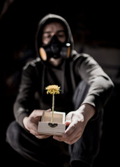 Hombre desenfocado con máscara ofreciendo una flor