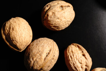 Walnuts on a black background. The light was dim.