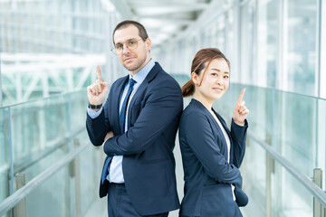 背中合わせに立つビジネスパーソン男女