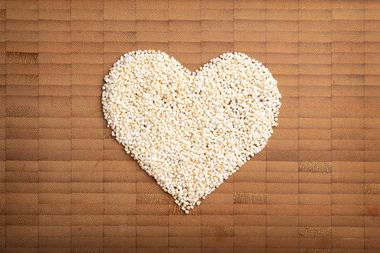 love concept image of heart shape made of  amarant grain on bamboo wooden background