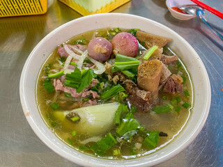 Pho beef noodles soup served with fresh vegetables in Saigon