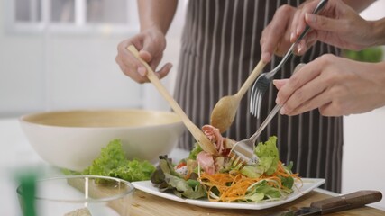 couple husband and wife cooking vegetable salad in kitchen together