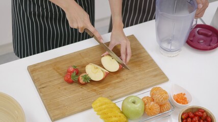 family couple husband and wife making fresh smoothie in kitchen together