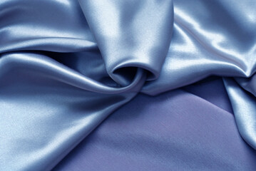 Smooth delicate blue silk or satin fabric for background. Delicate folds. Close-up.