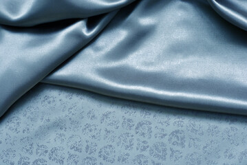 Smooth delicate blue silk or satin fabric for background. Delicate folds. Close-up.
