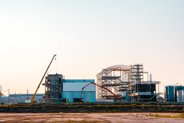 Fototapeta na wymiar Under Construction site of modern factory building, Unfinished factory building with sunset sky