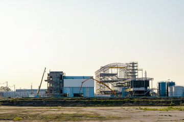 Under Construction site of modern factory building, Unfinished factory building with sunset sky