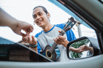 buskers feel happy when someone gives money from the car on the side of the road