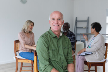 Diverse group of seniors talking during a group therapy session at home