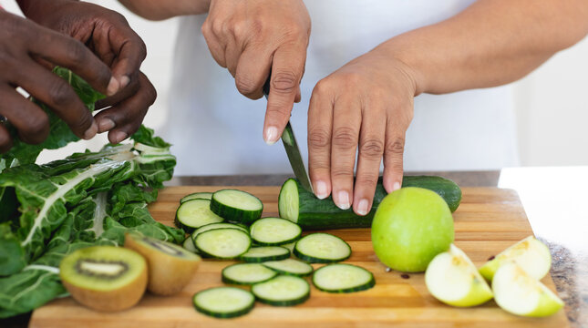 Senior african american man and woman preparing fruit and vegetable health drinks