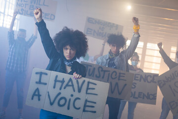 Multi ethnic group of people wearing face masks holding protest signs