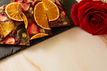 Red rose next to dried fruit chocolate bark