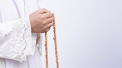 Asian muslim woman wearing prayer beads pray with tasbih in white background