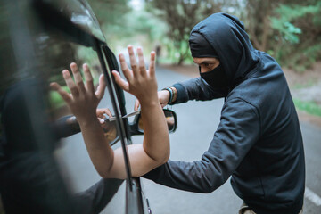 criminal robber in street holding knife near car on quiet street - obrazy, fototapety, plakaty