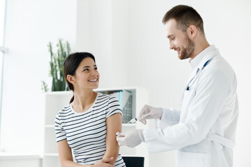 male doctor in a white coat injecting a woman's hand in a health hospital vaccination