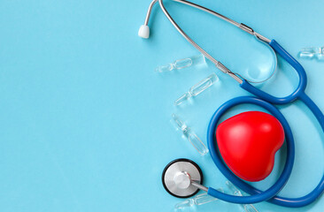 stethoscope, drug ampoules, red heart. heart on a blue background. view from above. space for text to the left. cardiology, pulse, healthier heart