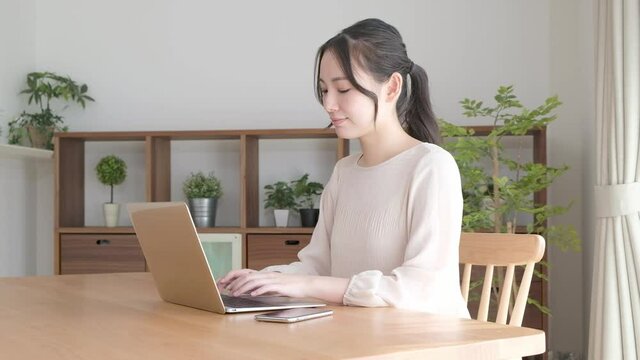 自宅で作業する若いアジア人女性