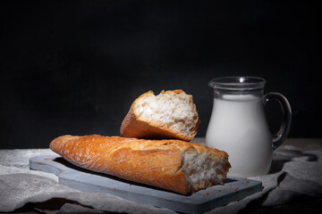 Fresh bread and buns on black background. Traditional bakery concept.