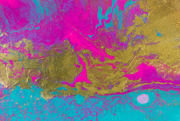 Gold glitter texture on fluorescent inks marble background.