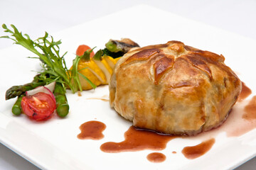 Fillet Wellington in puff pastry with roasted vegetables, Veal Wellington, close up view