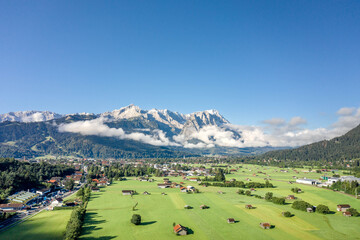 Fototapeta na wymiar Aerial drone shot of village Garmisch Partenkirchen with view of Zugspitze in fog