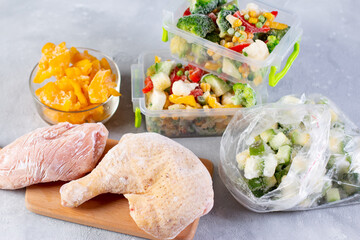 Plastic bags and containers with different frozen vegetables and meat on table, top view