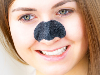 Woman applying pore strips on nose