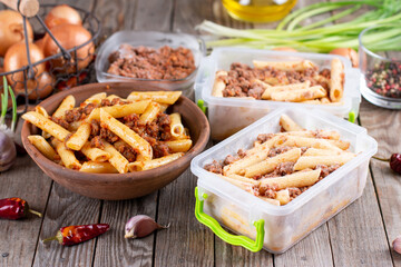 Frozen pasta, ready meal. Frozen pasta with minced meat on a wooden background