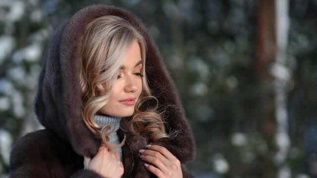 Seductive luxury female posing touching brown hood fur coat. Medium close up shot on 4k RED camera