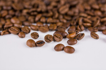 a roasted coffee beans sprinkled on white background