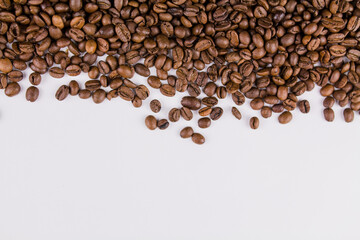 a roasted coffee beans sprinkled on white background